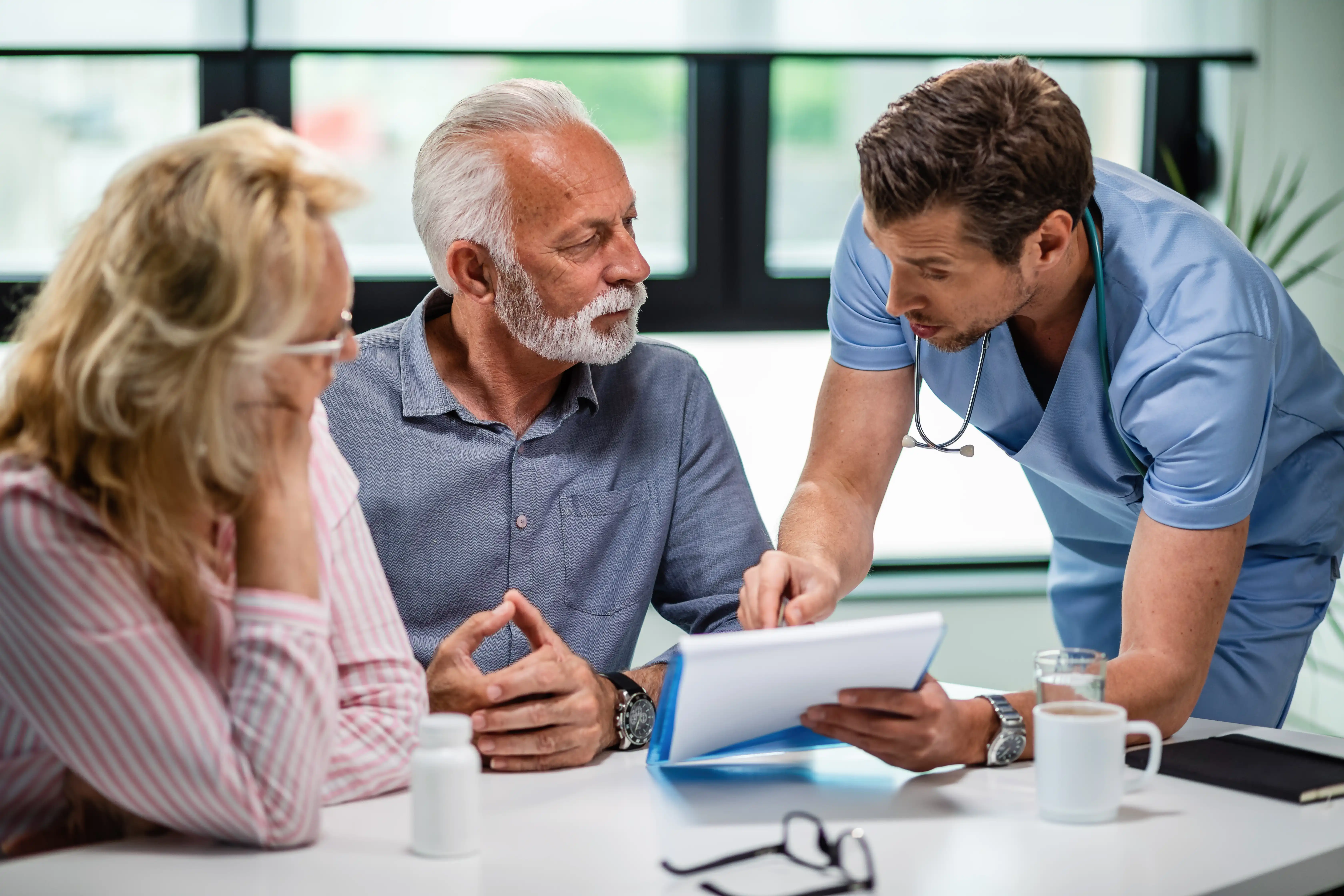 serious-doctor-discussing-with-senior-couple-about-their-medical-documents-appointment-clinic serious-doctor-discussing-with-senior-couple-about-their-medical-documents-appointment-clinic